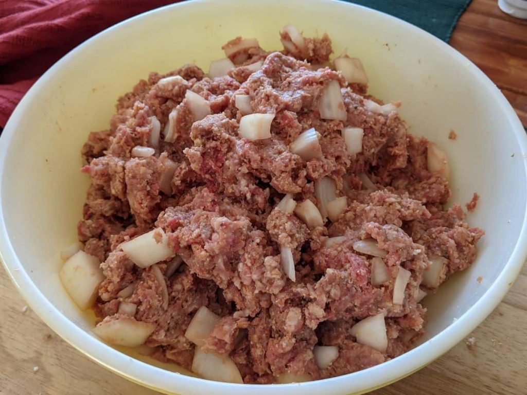 mixed raw ingredients for meatloaf in a mixing bowl