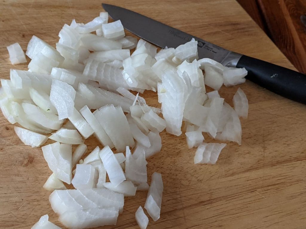 chopped onions and a knife on a cutting board