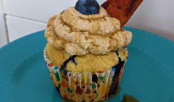blueberry pancake cupcake sitting on a blue dish