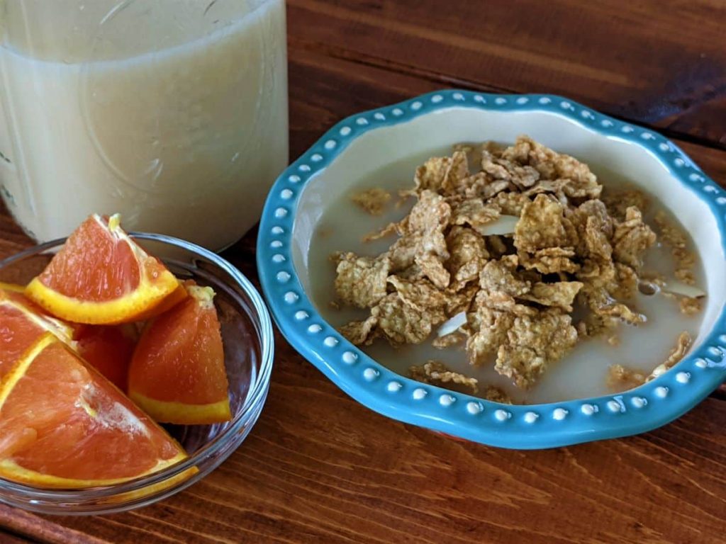cereal, oranges, and oat milk on a table