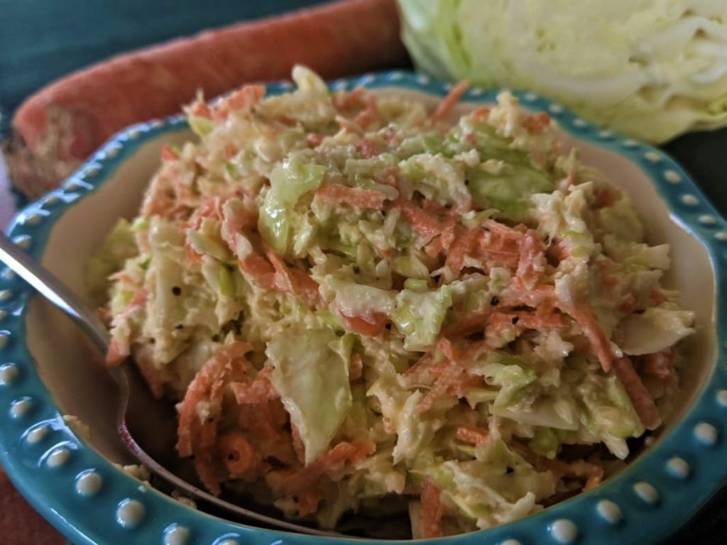 a bowl of farmhouse coleslaw pictured with ingredients