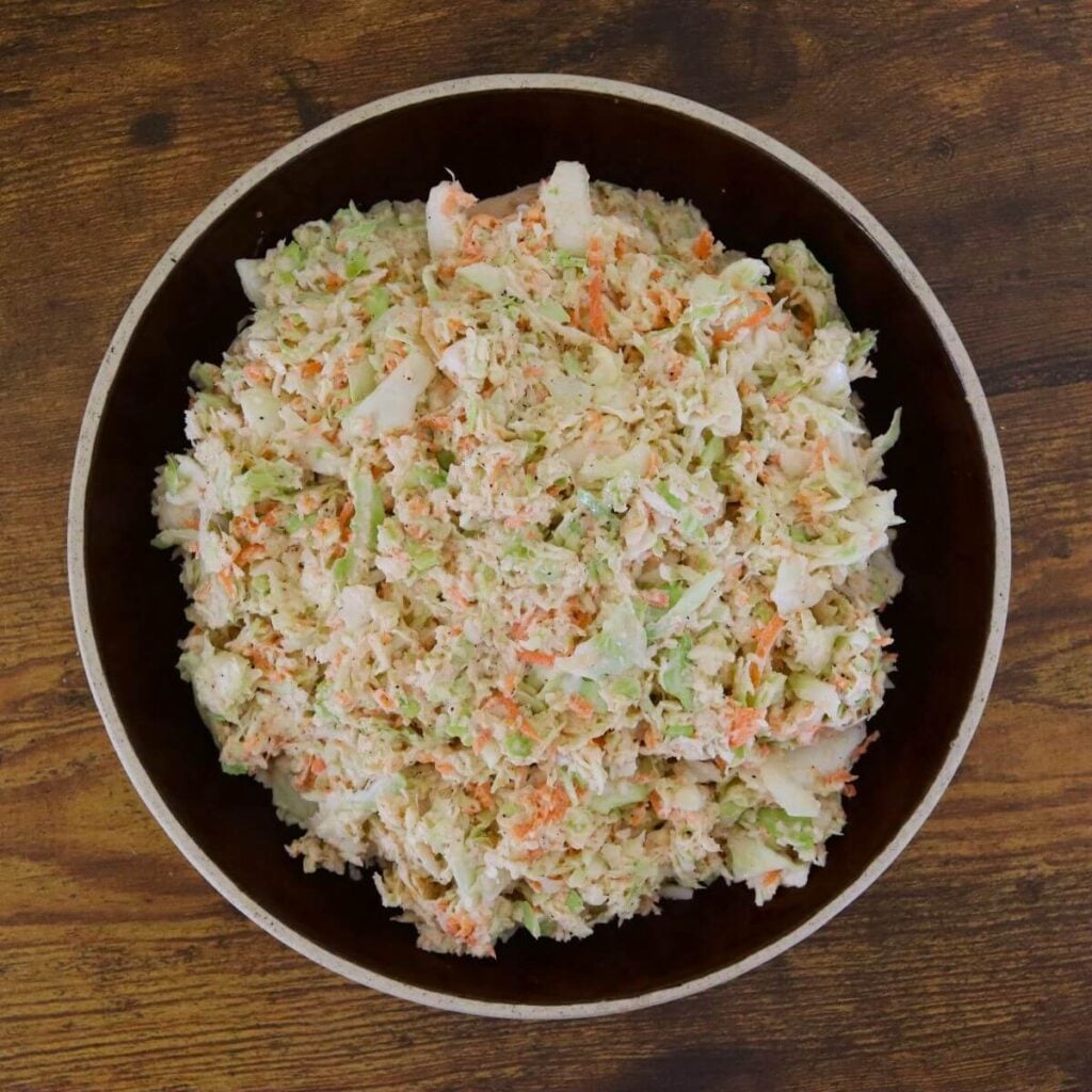 Finely grated cabbage and carrot coleslaw in a large bowl.