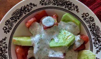 dill dressing poured over vegetables in a bowl