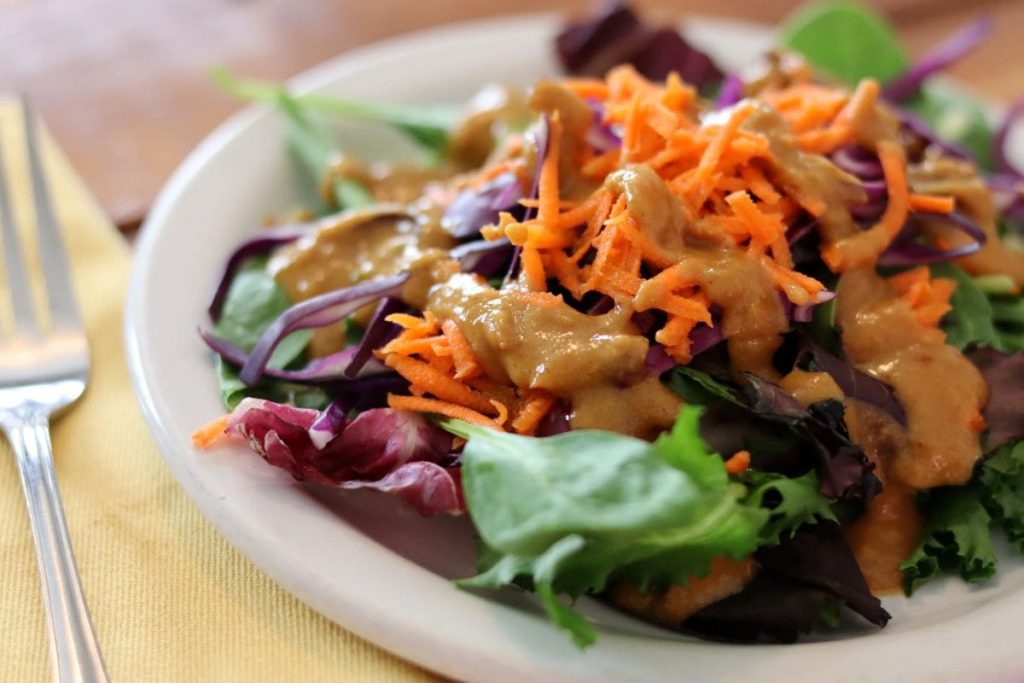 salad and dressing on a plate with a fork
