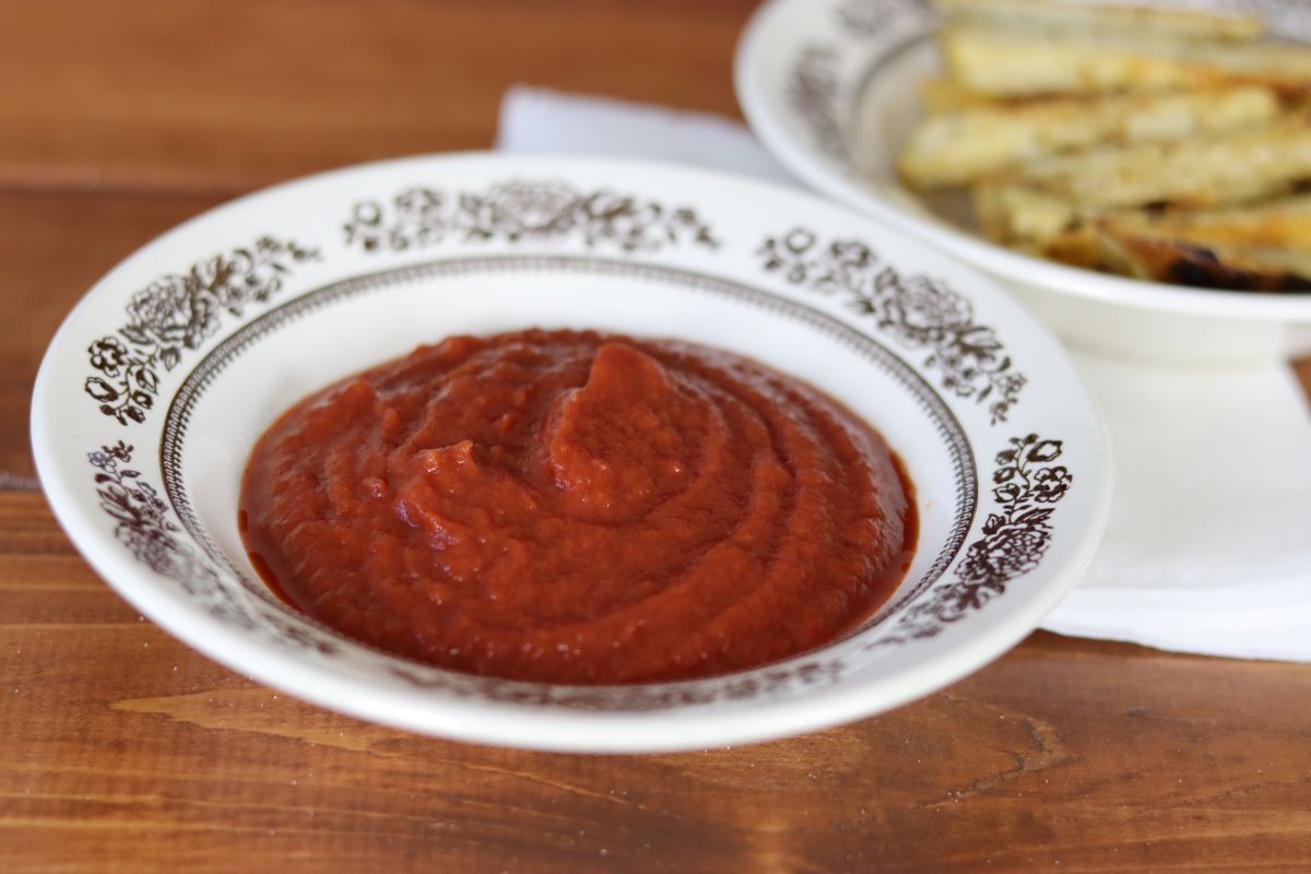 ketchup in a small dish on a table.
