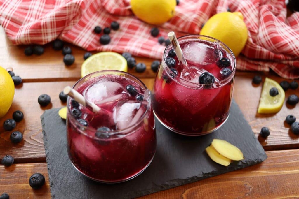 sparkling blueberry lemonade in glasses with straws