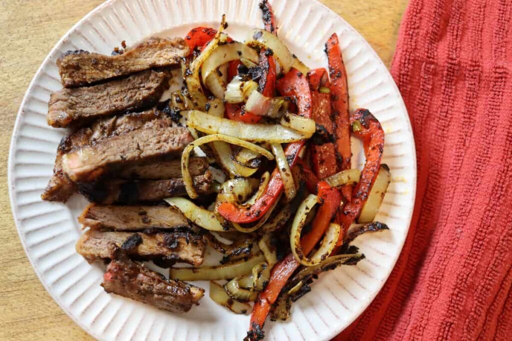 sliced steak and vegetables for a recipe on a plate
