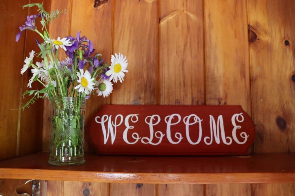 wildflowers in a vase by a welcome sign