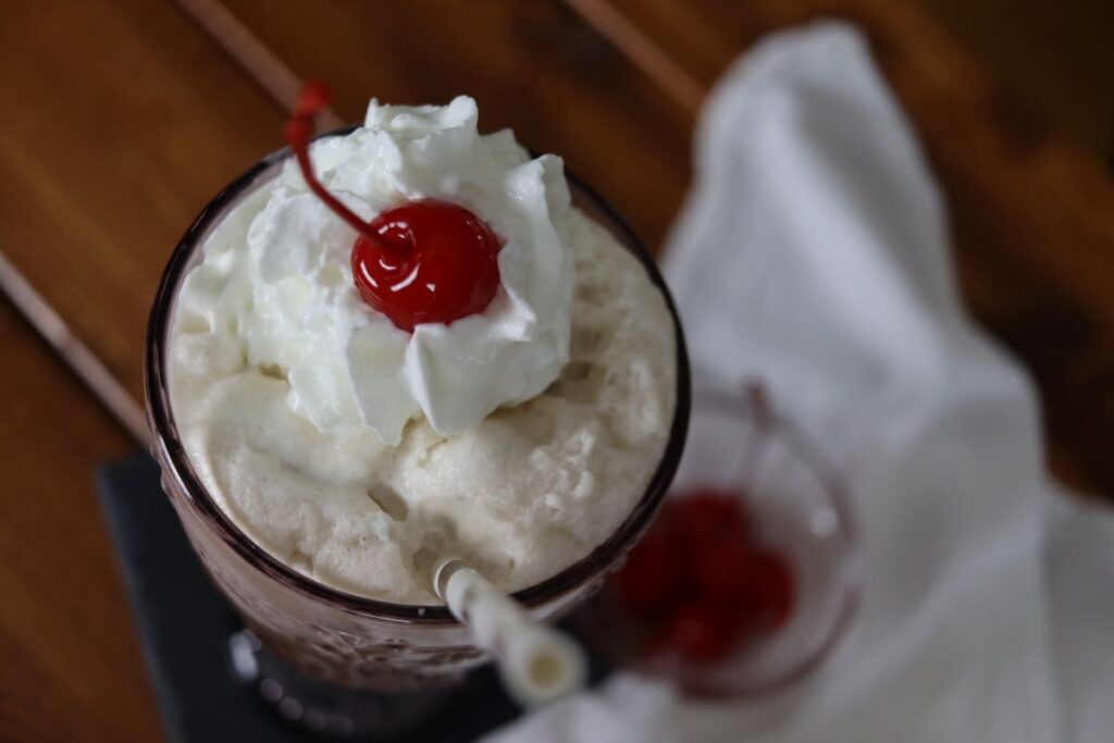 ice cream beverage with whipped cream and cherry on top