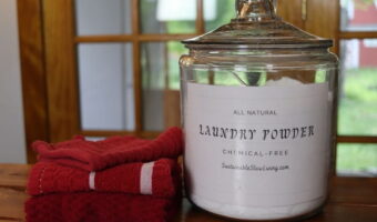 container of simple diy laundry powder on a table with towels