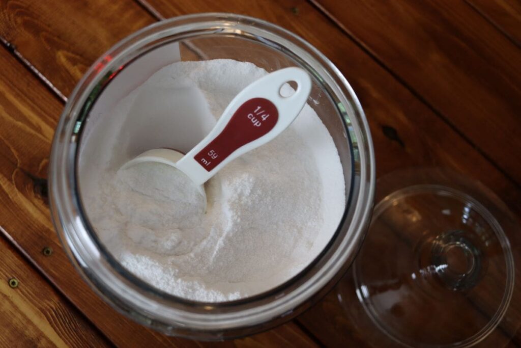 measuring cup in a container of handmade laundry detergent