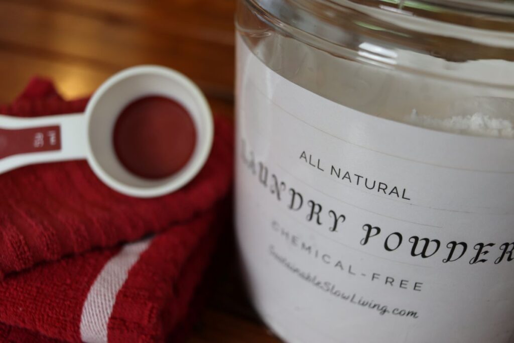 simple diy laundry powder with a measuring cup and towels