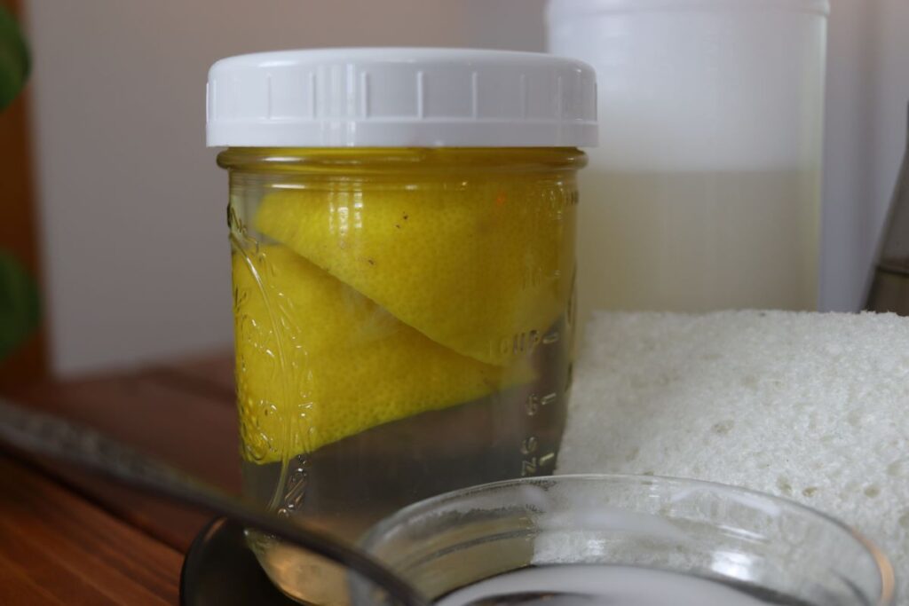 lemons infusing in a jar of white vinegar