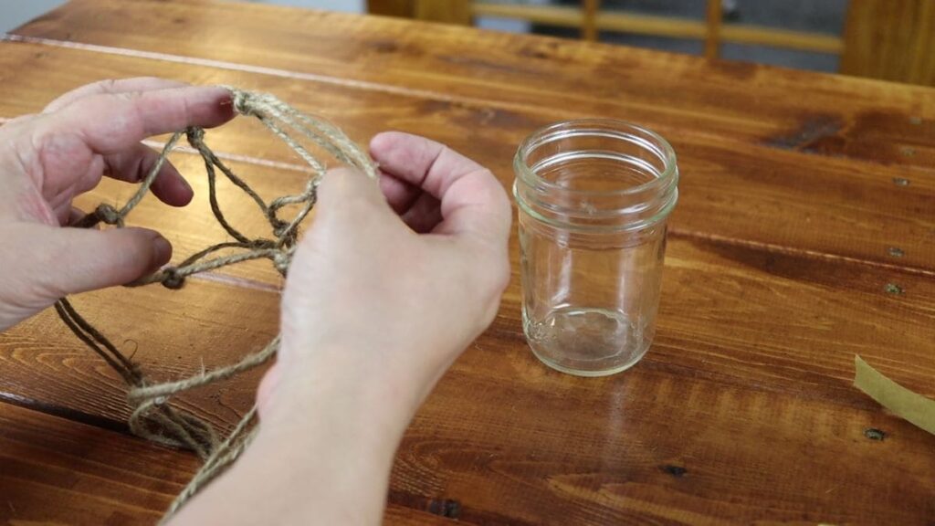 putting a mason jar in a hanging jute twine holder