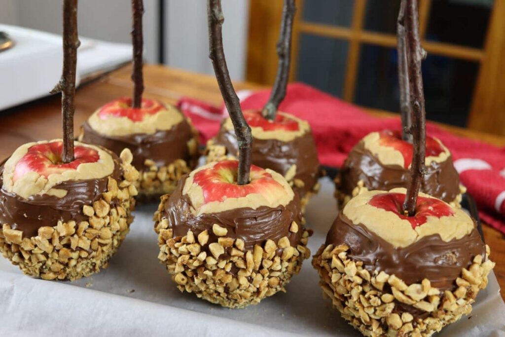 6 gourmet dipped apples on a parchment lined sheet pan