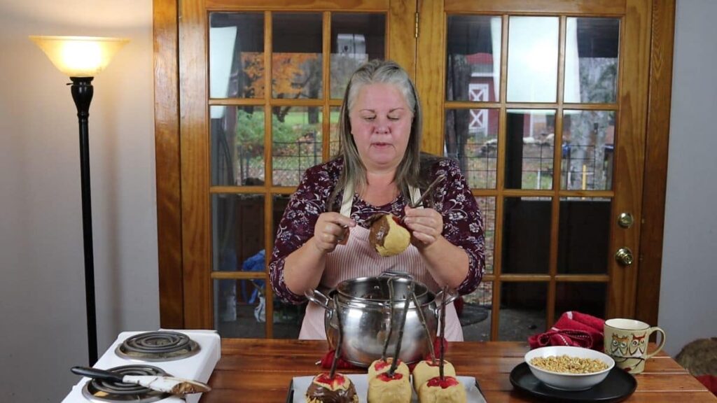 woman spreading chocolate on a homemade peanut butter candy apple