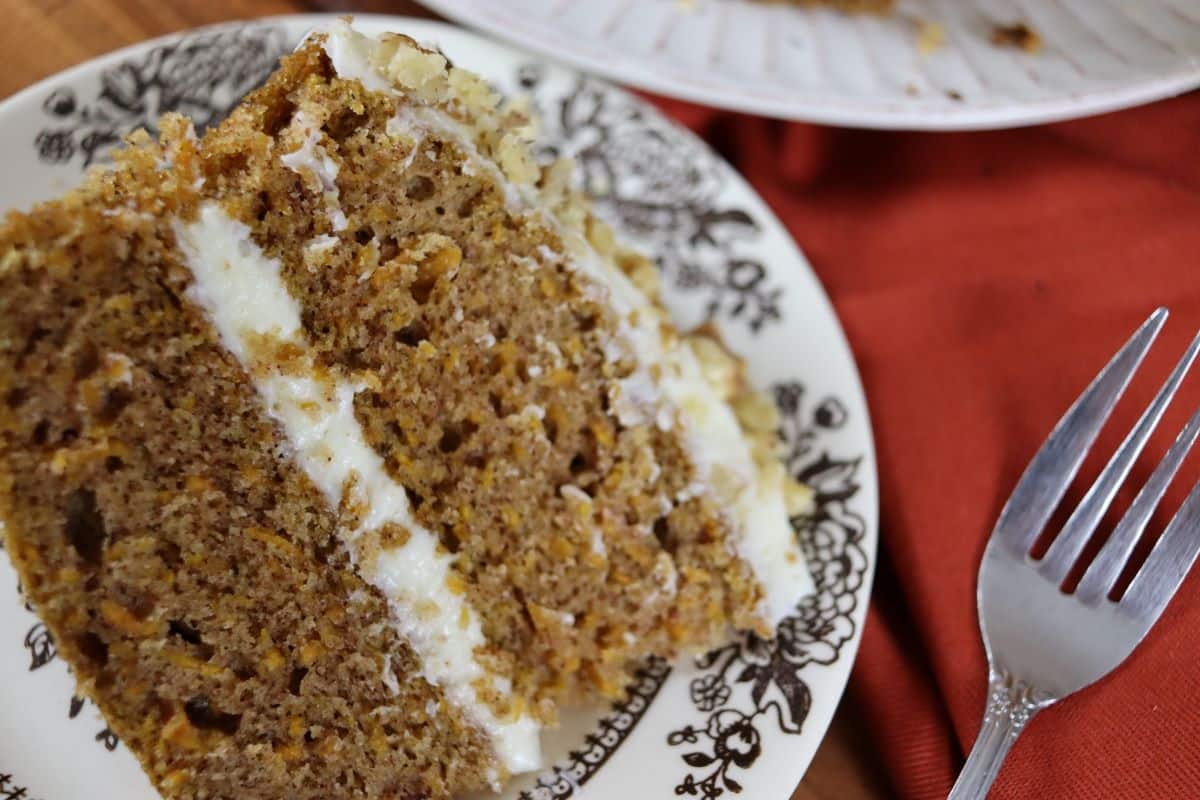 Piece of freshly made cake laying on it's side on a small dish with a fork.