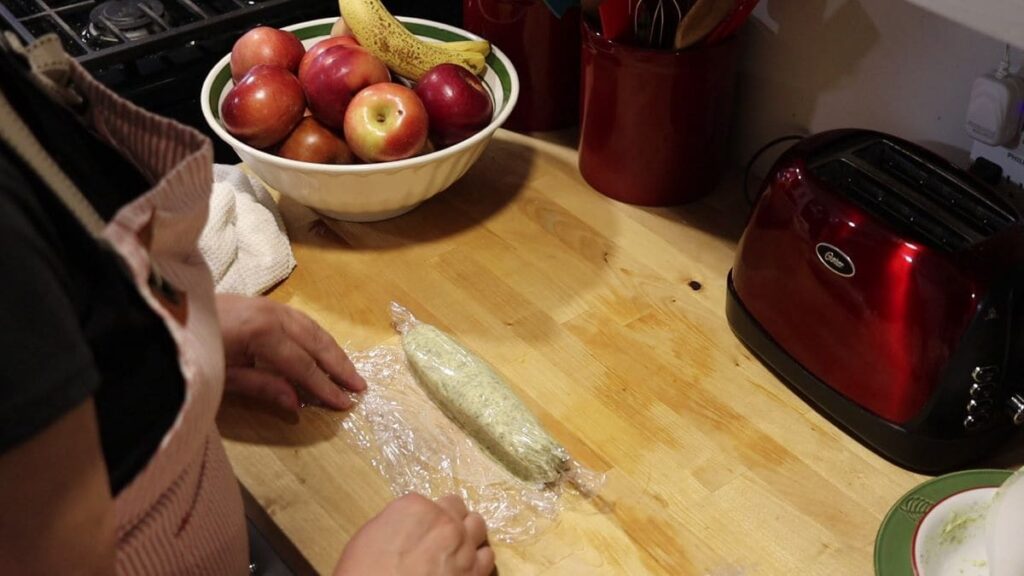 woman rolling compound butter in plastic wrap