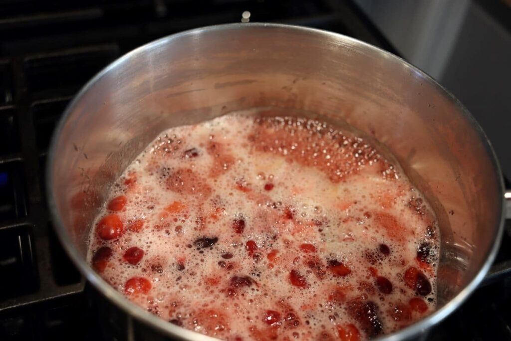 cranberries and honey simmering in a pot