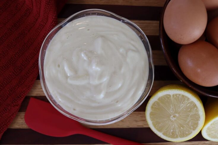 homemade mayonnaise in a dish on a counter with ingredients used to make it