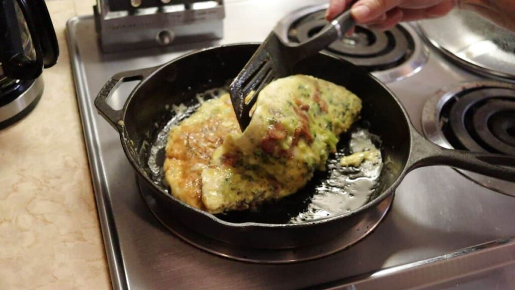 flipping an omelette in a cast iron skillet