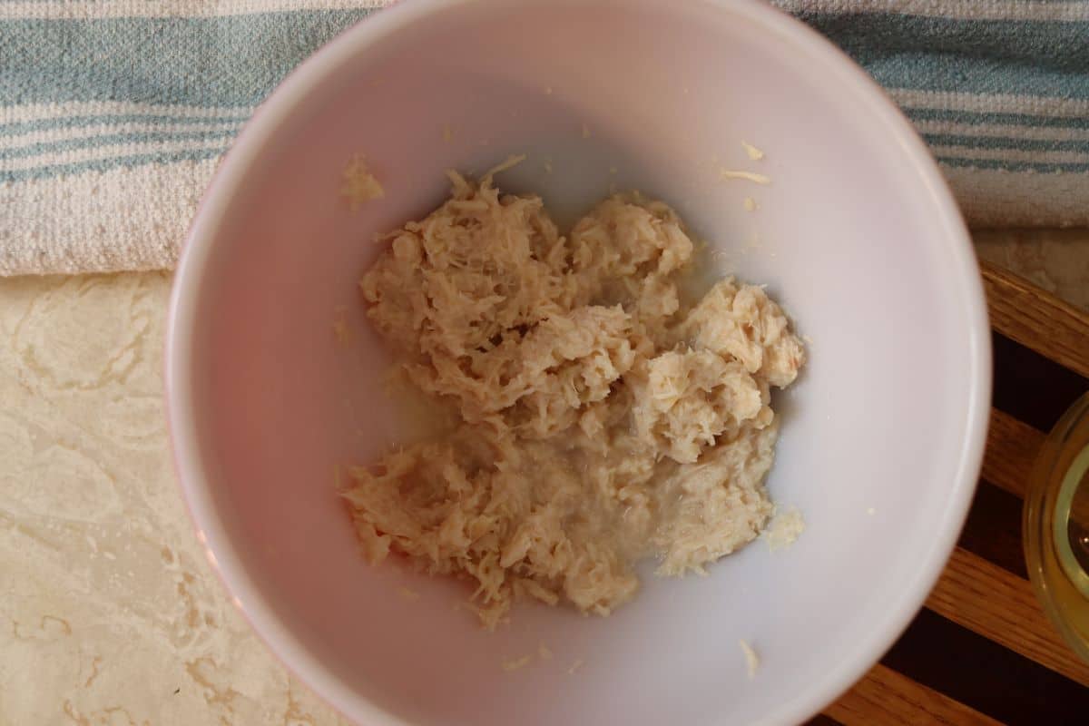 mashed canned chicken in a bowl on a counter.