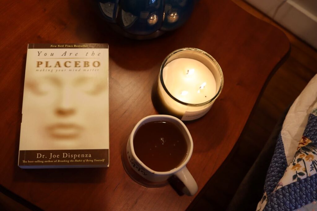 book, tea, and candle set out on a table for a slow living winter afternoon