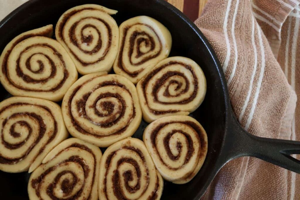 cast iron skillet cinnamon rolls ready to go in oven in a pan