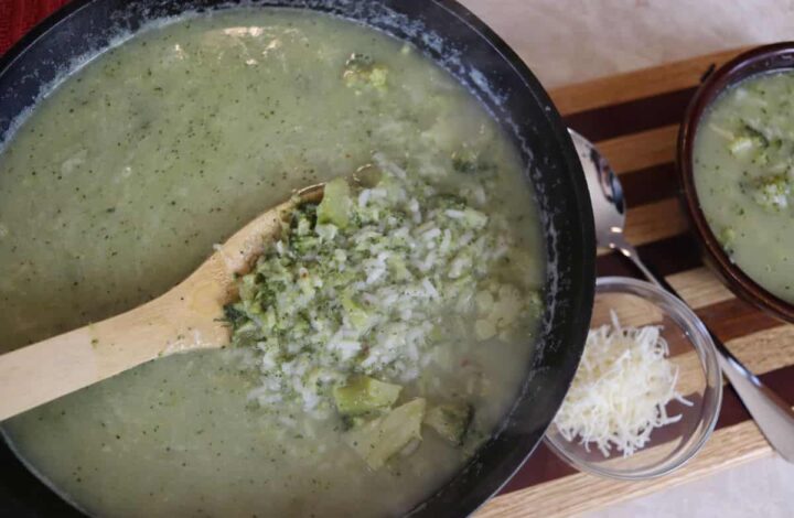 A pot of italian broccoli soup being served with a spoon