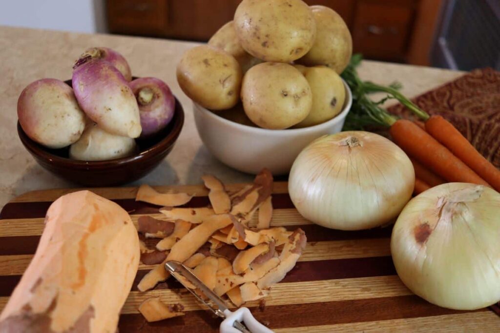 partially peeled sweet potato with other root vegetables on a counter