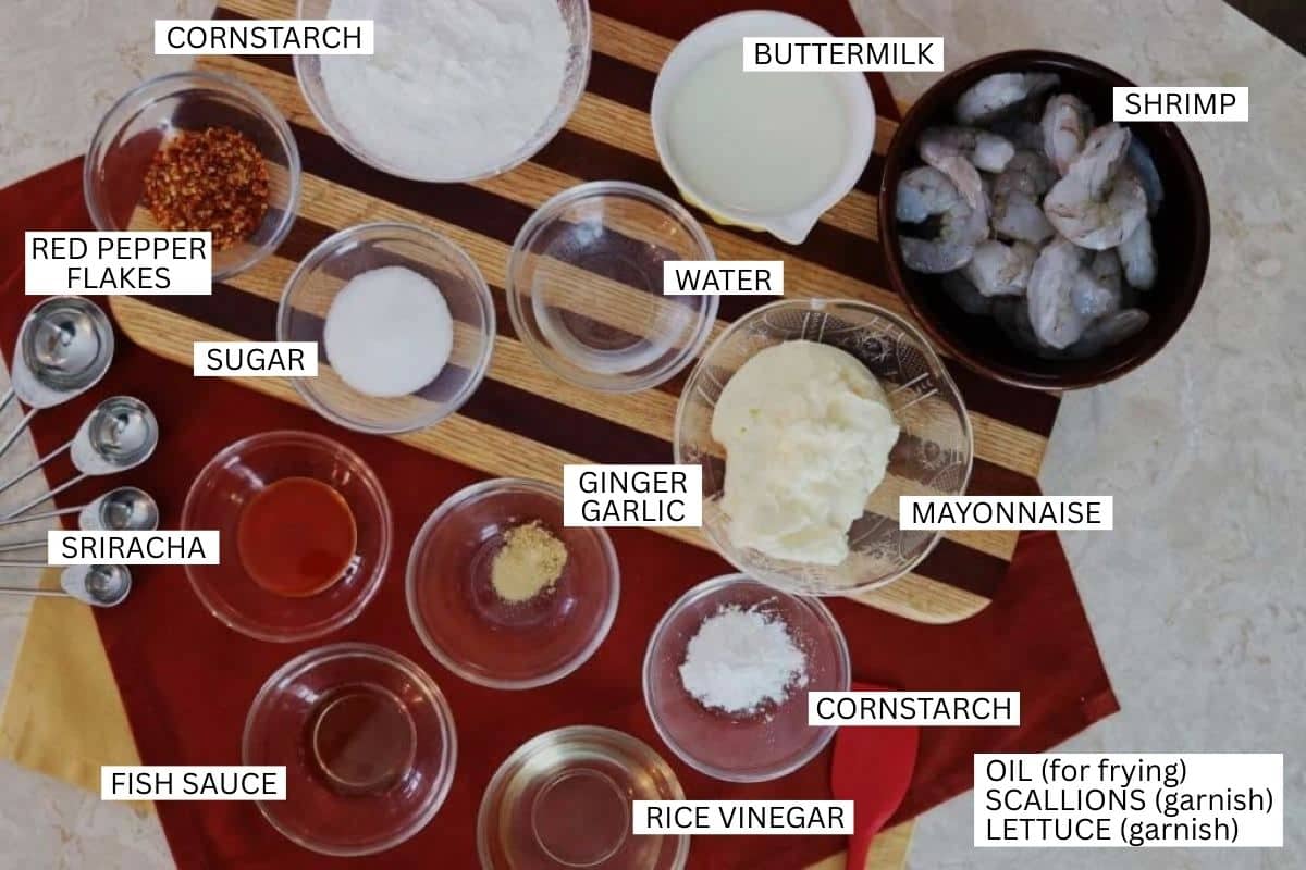 Various labeled ingredients in bowls and spoons, including shrimp, mayo, ginger garlic, buttermilk, cornstarch, water, sugar, red pepper flakes, sriracha, fish sauce, rice vinegar, and garnishes.