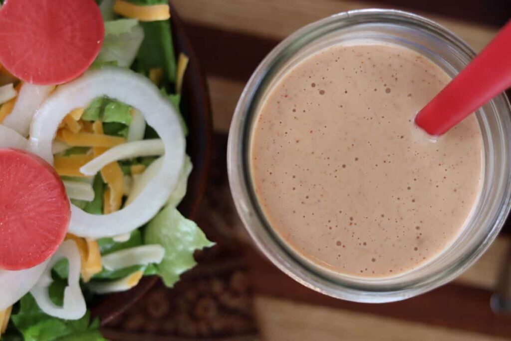overview of thousand island dressing in a jar next to a salad