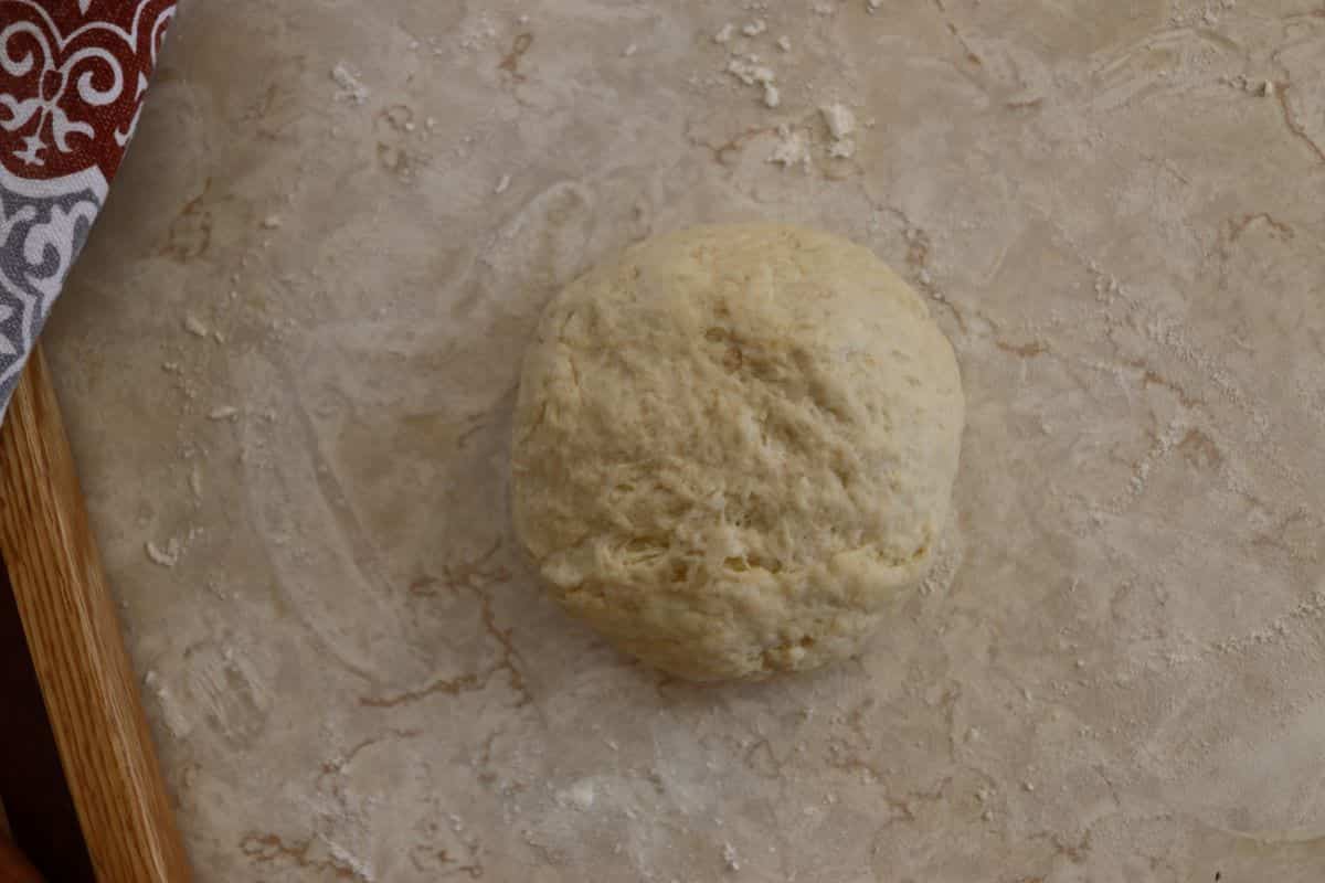 Ball of dough sitting on a countertop.