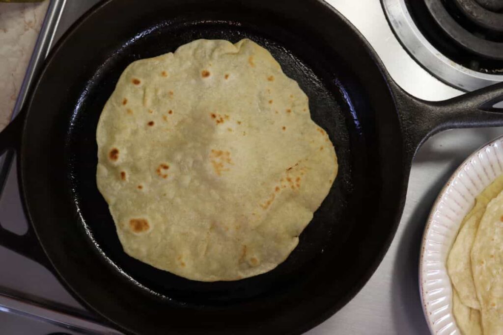 tortilla shell cooking in a fry pan