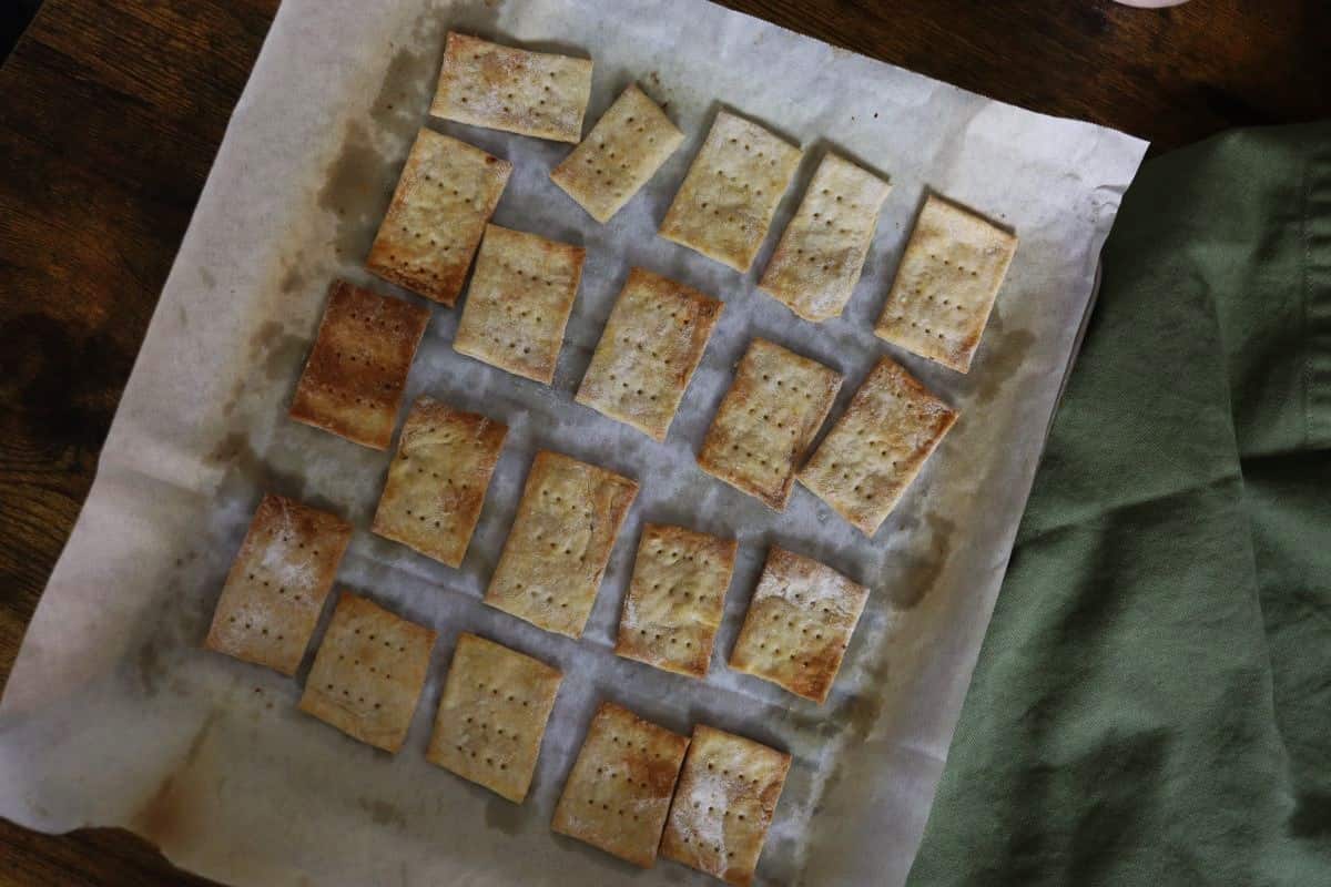 Rectangular baked crackers laid out on a parchment lined sheet pan.