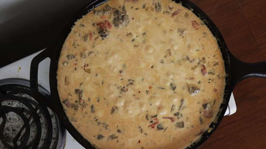 freshly made sausage dip simmering in a cast iron skillet