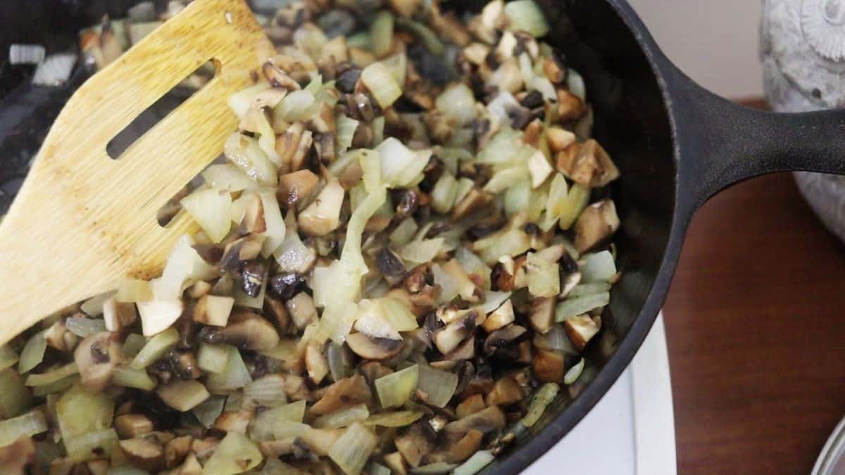 Cooked chopped onions and mushrooms in a cast iron skillet.