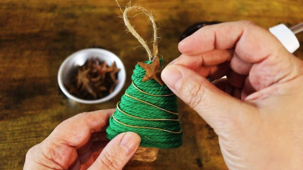 gluing a star to the top of a diy tree shaped ornament