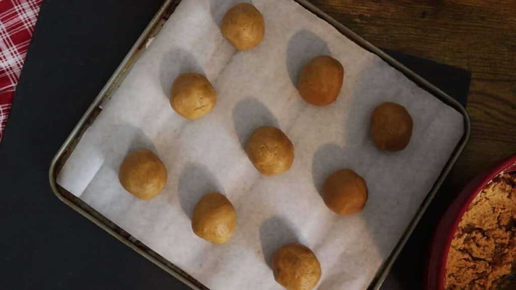 cookie dough rolled into balls on a baking sheet