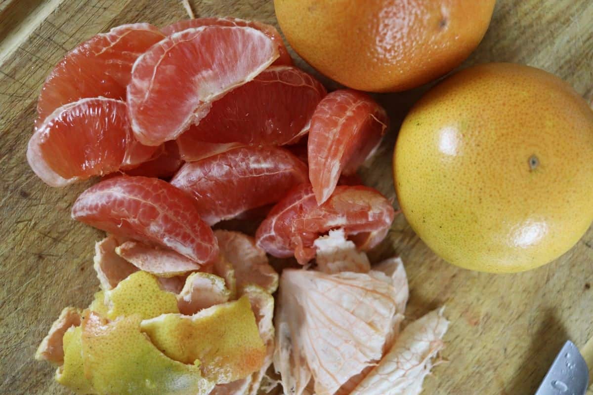 grapefruit segments, pith, and peels on a counter.