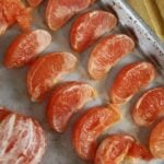 fresh grapefruit slices laid out on a parchment lined baking sheet.