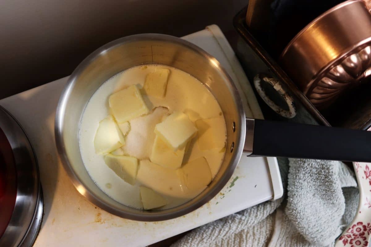 butter, sugar, and heavy cream in a saucepan on a stovetop.