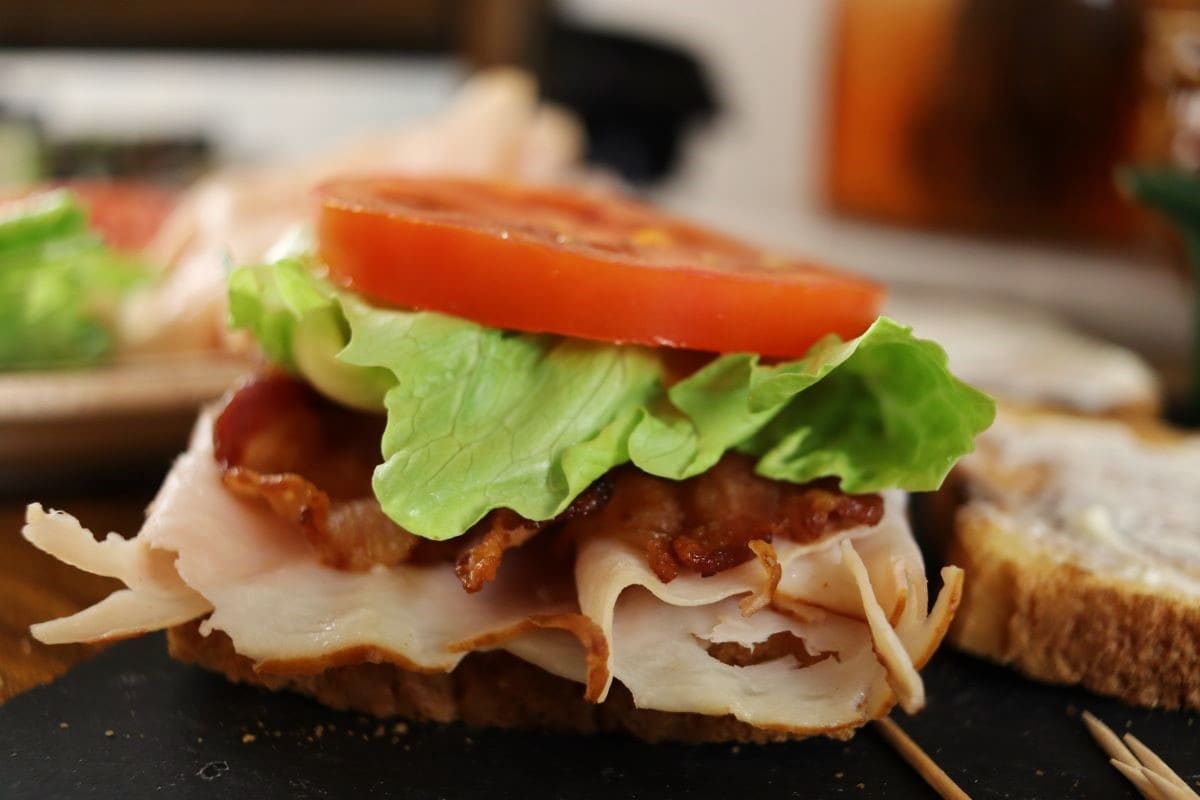 turkey, bacon, lettuce, and tomato layered on a slice of toast.