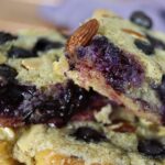 Stacked pieces of french toast pastries with blueberries and almonds visible in them.