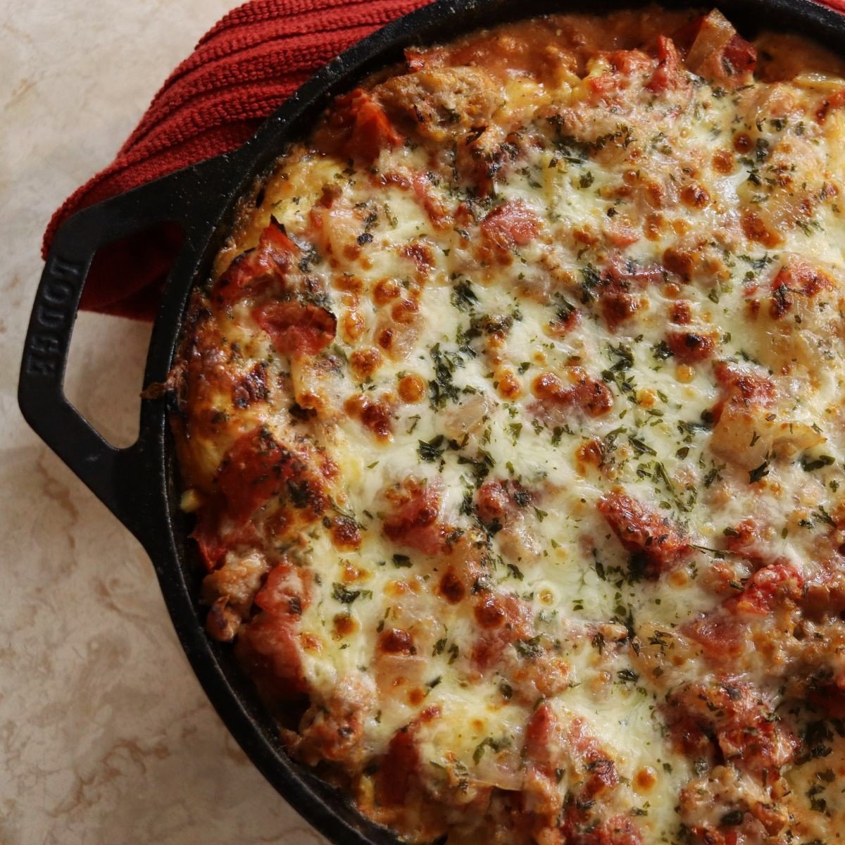 overview of a cast iron skillet with baked lasagna in it.