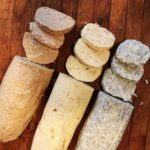 three different butter logs sitting on a table with slices cut off at the end of them.