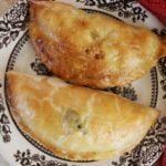 Two hand pies sitting next to one another on a dish.