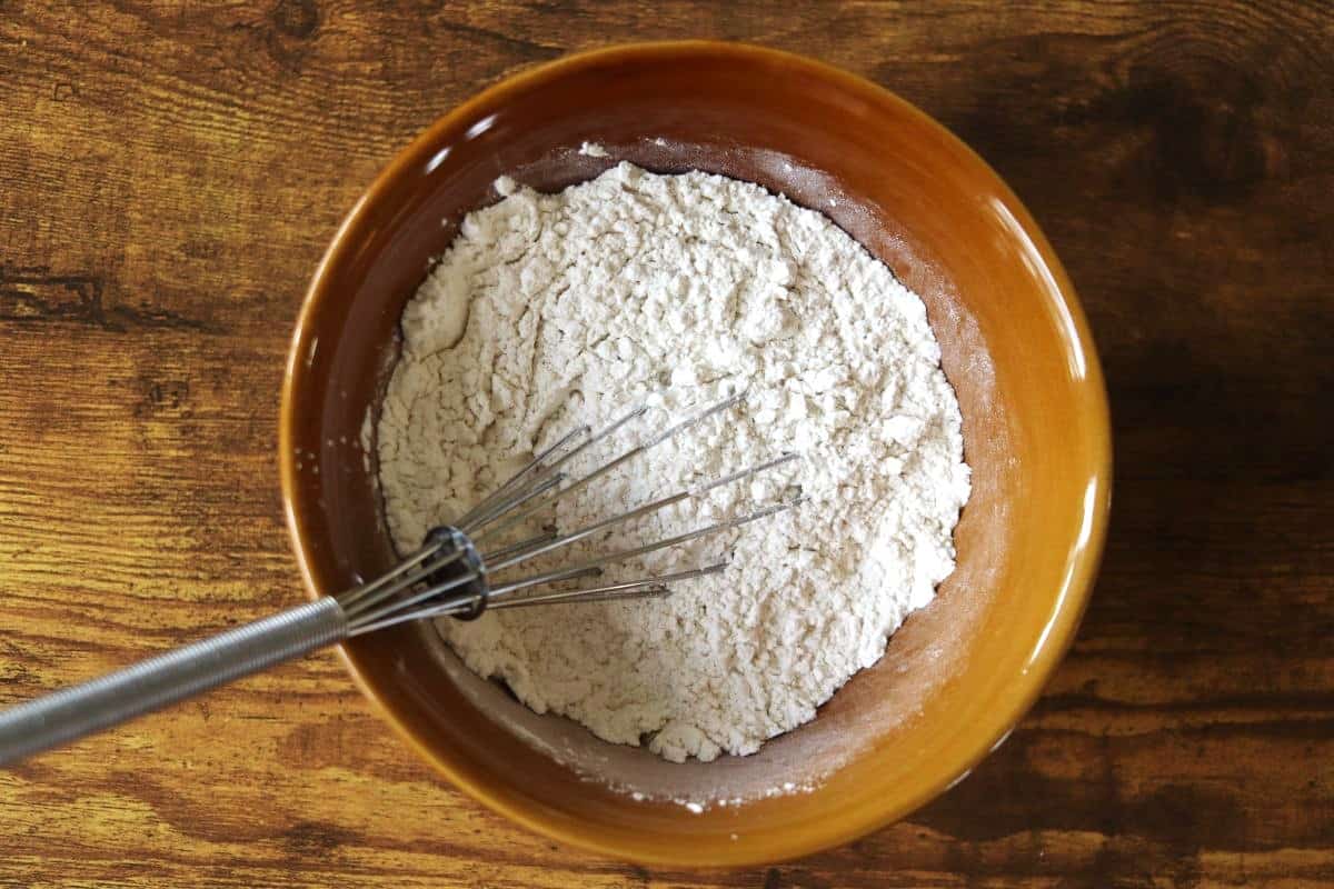 Flour mixture in a bowl with a whisk in it.