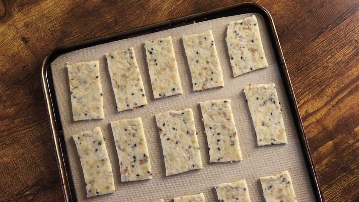 Rectangular shaped pieces of dough  on a silicone lined baking sheet.