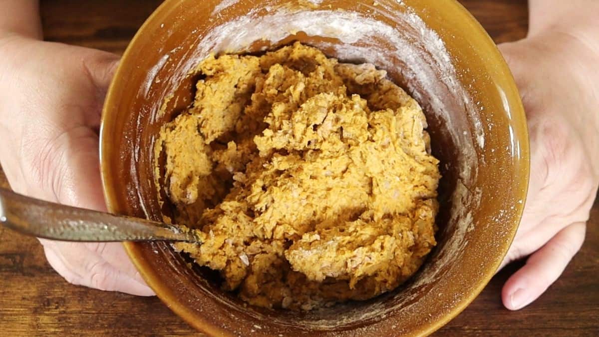 Orange colored dough in a bowl.